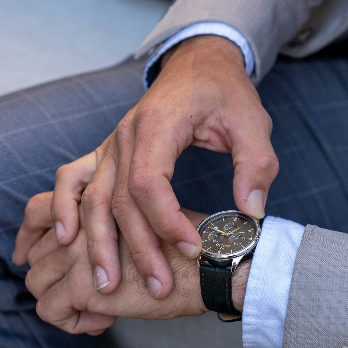 person wearing silver and black round analog watch